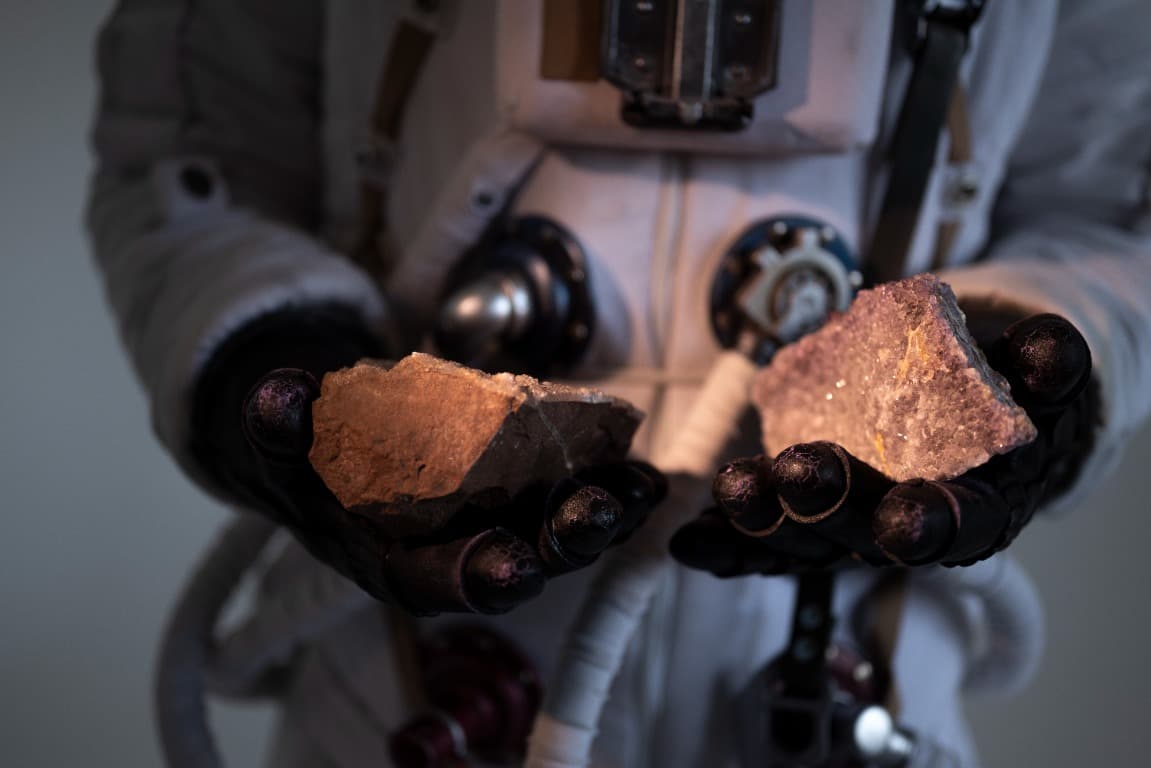 Astronaut holding mineral rock samples